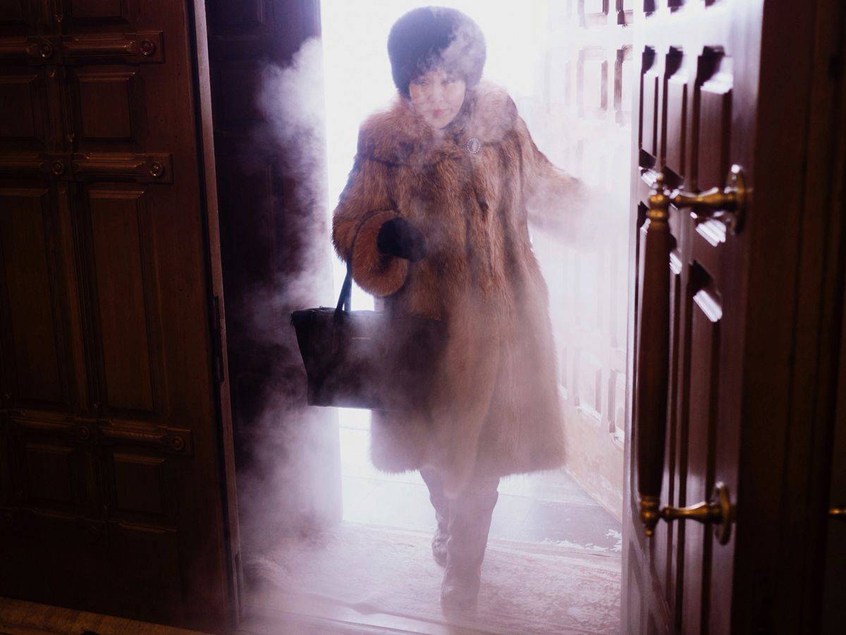 A local woman enters Preobrazhensky Cathedral in a swirl of freezing mist.